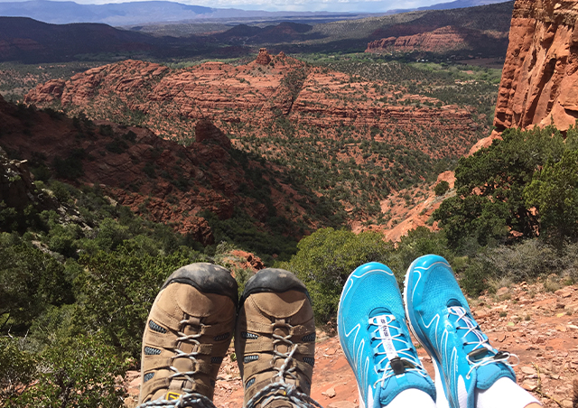 At the top of Cathedral Rock in Sedona with our feet to provide visual perspective of the vast valley below.